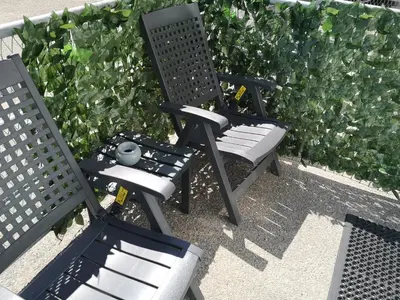 two chairs sitting next to each other in front of a hedge at Beach Studio, No Sea View, Public Paid Parking in Zandvoort