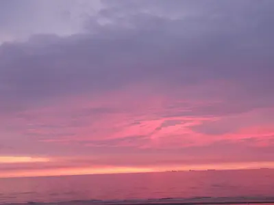 a sunset over the ocean with a pink at Beach Studio, No Sea View, Public Paid Parking in Zandvoort