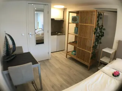 a living room with a bed and a dining room at Beach Studio, No Sea View, Public Paid Parking in Zandvoort