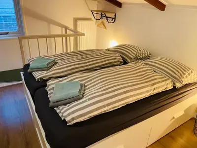 a bed with two pillows on it in a room at Beach House Parallel in Noordwijk