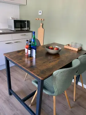 a wooden table with bottles and a bowl of fruit on it at Beach House Parallel in Noordwijk