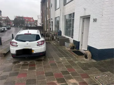 a white car parked in front of a building at Beach House Parallel in Noordwijk