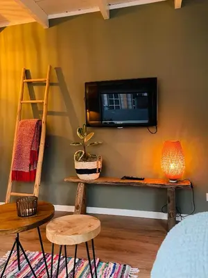 a living room with a tv on a wall at Beach House Parallel in Noordwijk