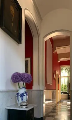 a vase with purple flowers on a table in a hallway at Oude Postkantoor de Rijp in De Rijp