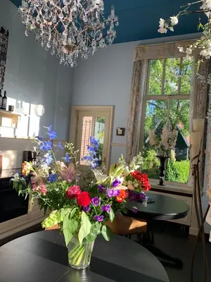 a vase filled with flowers sitting on a table at Oude Postkantoor de Rijp in De Rijp