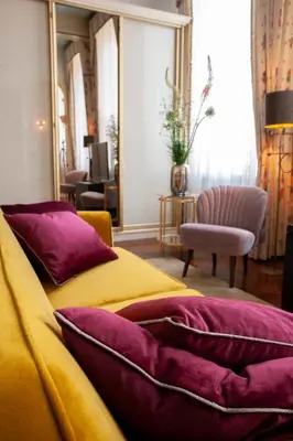 a bedroom with a bed with purple and yellow pillows at Oude Postkantoor de Rijp in De Rijp
