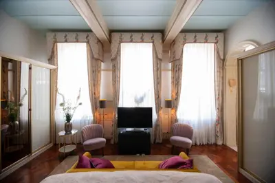 a bedroom with a bed and a tv and windows at Oude Postkantoor de Rijp in De Rijp
