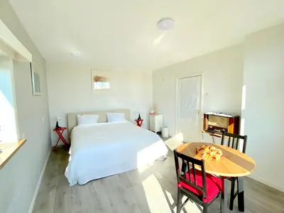 a bedroom with a white bed and a table at Who's Anton for you or two, Monnickendam near Amsterdam in Monnickendam