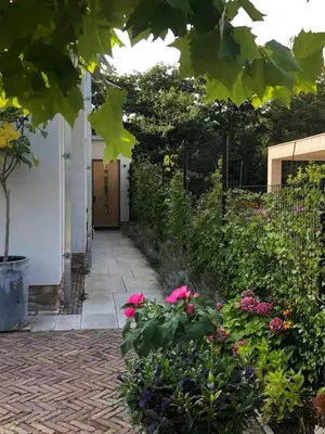 a garden with pink flowers and a fence at Luxe B&B 