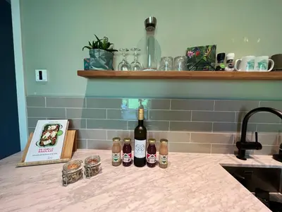 a counter with three bottles of wine and a book at Luxe B&B 