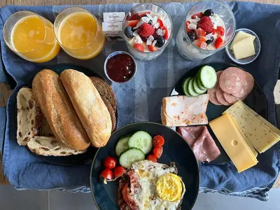 a table with two plates of breakfast foods and drinks at Luxe B&B 