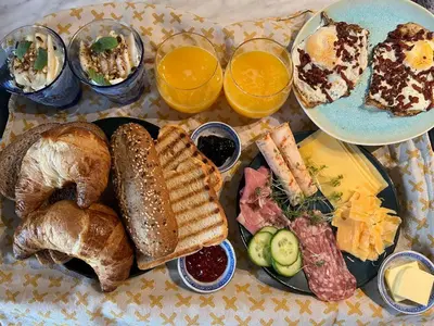 a table topped with plates of bread and pastries at Luxe B&B 