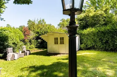 a lamp post in a yard with a yellow shed at Casa Allegria - Zuiderbosch in Bergen