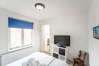 a bedroom with a bed and a tv and a window at Zonnebloem in Zandvoort