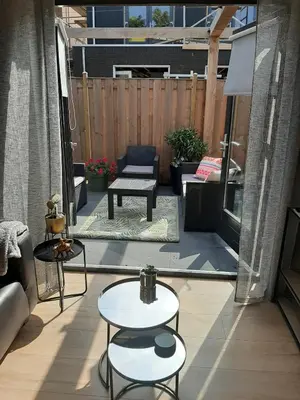a patio with two tables and a bench on a balcony at Zomerhuis Carolina in Egmond aan Zee