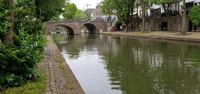 a river with a bridge in a city at Werfkelder aan de Oudegracht in Utrecht