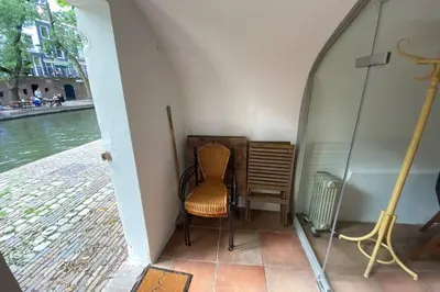 a chair sitting in a room next to the water at Werfkelder aan de Oudegracht in Utrecht
