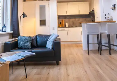 a living room with a couch and a kitchen at La Playa in Egmond aan Zee