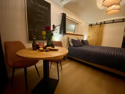a room with a table and a bed and a bed and a table and chair at Style Gardenhouse Zwanenburg near AMSTERDAM, HAARLEM, ZANDVOORT in Zwanenburg