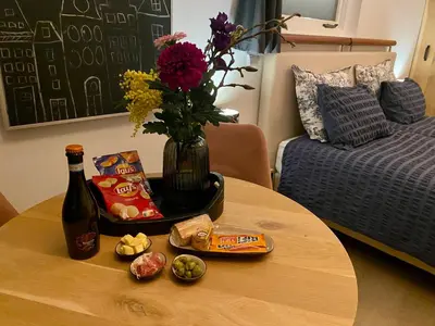 a table with a bottle of wine and a vase of flowers at Style Gardenhouse Zwanenburg near AMSTERDAM, HAARLEM, ZANDVOORT in Zwanenburg