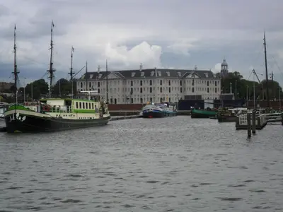 a boat is docked in the water near a building at Anna Houseboat in Amsterdam