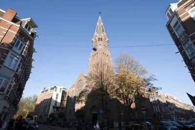 a tall building with a clock tower on a street at The Little Townhouse in Amsterdam
