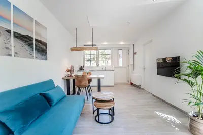 a living room with a blue couch and a table at Good Vibes Romantic Studio incl free private parking in Zandvoort