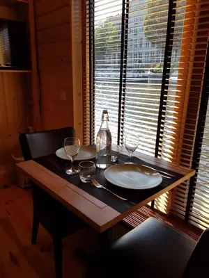 a wooden table with two glasses and a bottle on it at Mar&Mar Houseboat Studio in Amsterdam