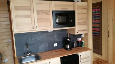 a kitchen with wooden cabinets and a sink and a microwave at Mar&Mar Houseboat Studio in Amsterdam