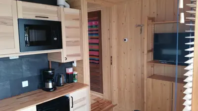 a kitchen with wooden cabinets and a microwave and a tv at Mar&Mar Houseboat Studio in Amsterdam