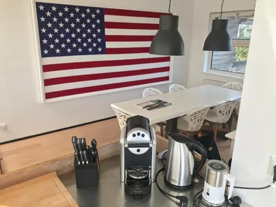 an espresso machine on a counter with an american flag on the wall at The Boathouse with boat in Aalsmeer