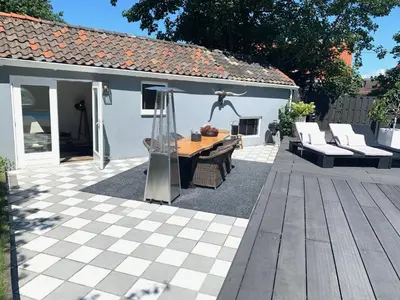 a patio with a table and chairs and a house at Finch guesthouse in Zandvoort