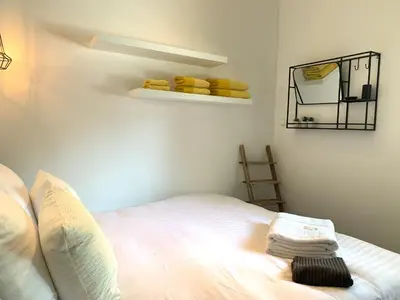 a bedroom with a bed and a shelf with towels at Finch guesthouse in Zandvoort
