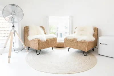 a room with two wicker chairs and a fan at Luttik in Alkmaar