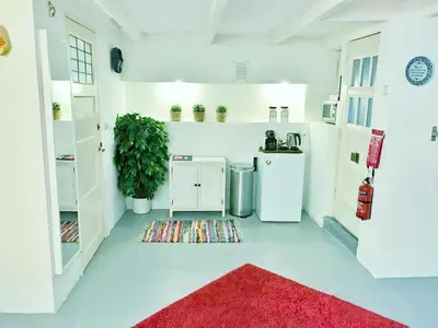 a white kitchen with a red rug on the floor at Amsterdam Home in Amsterdam