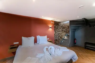 a bedroom with a bed with two swans on it at beach apartments in Zandvoort