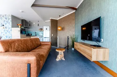 a living room with a couch and a flat screen tv at beach apartments in Zandvoort