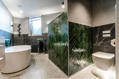 a bathroom with a tub and a toilet in it at beach apartments in Zandvoort