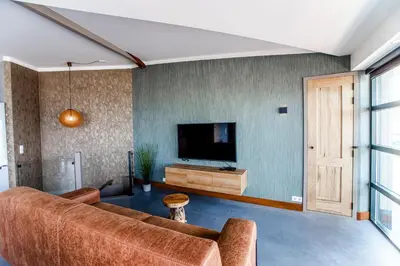 a living room with a couch and a flat screen tv at beach apartments in Zandvoort
