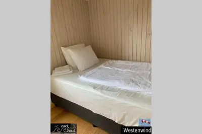 a small bed with white sheets and pillows at Holiday-Chalet Westenwind 4p. Amsterdam & Beach in Opmeer