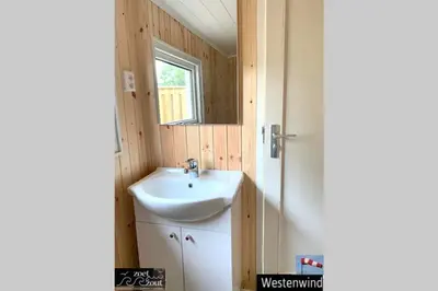 a small bathroom with a sink and a window at Holiday-Chalet Westenwind 4p. Amsterdam & Beach in Opmeer