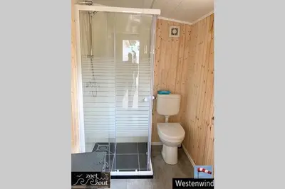 a bathroom with a toilet and a glass shower at Holiday-Chalet Westenwind 4p. Amsterdam & Beach in Opmeer