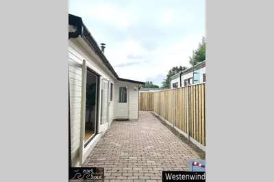 a brick walkway between two houses with a fence at Holiday-Chalet Westenwind 4p. Amsterdam & Beach in Opmeer