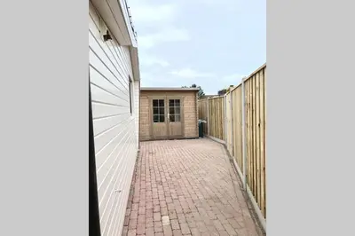 a brick sidewalk next to a fence next to a building at Holiday-Chalet Westenwind 4p. Amsterdam & Beach in Opmeer