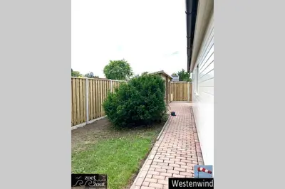 a backyard with a fence and a brick walkway at Holiday-Chalet Westenwind 4p. Amsterdam & Beach in Opmeer