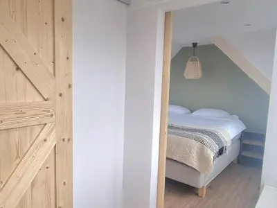 a bedroom with a bed and a staircase in a room at Tip! Noordwijk city center house in Noordwijk aan Zee