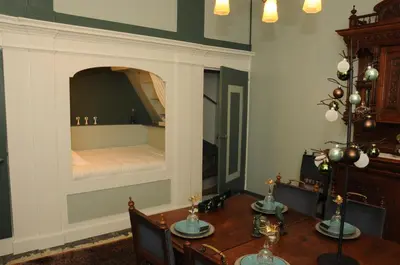 a bedroom with a bed with a table and chairs at Bed en kerk monumentale 2 slaapkamer woning in Hoorn