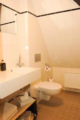 a white bathroom with a sink and a toilet at Bed en kerk monumentale 2 slaapkamer woning in Hoorn