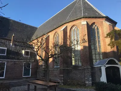 a large brick building with a bench in front of it at Bed en kerk monumentale 2 slaapkamer woning in Hoorn