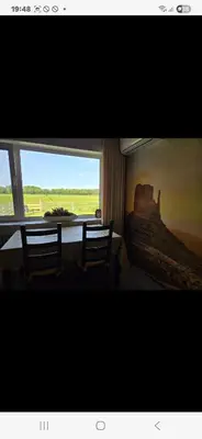 a room with two chairs and a large window at De indiaan in Noord-Scharwoude